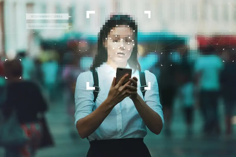 Woman in street using mobile device with blurred face