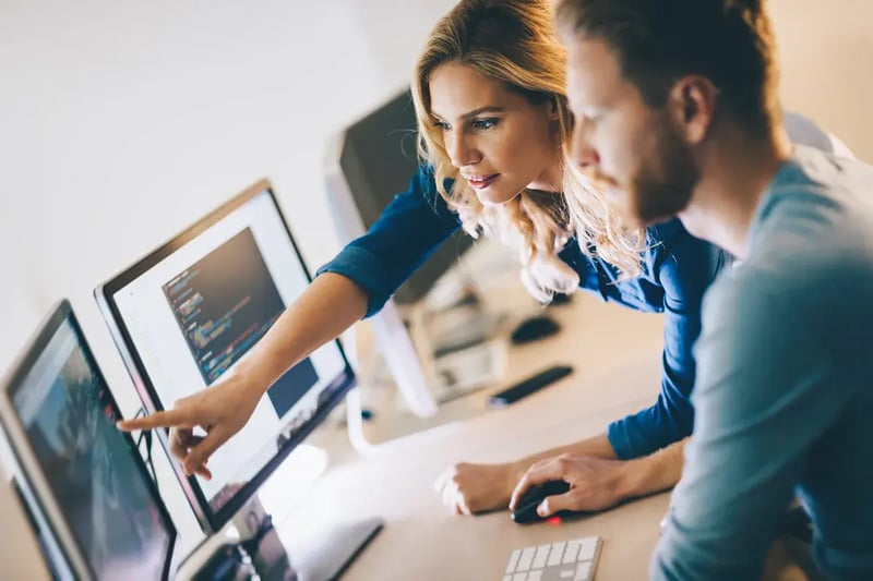 Two colleagues working at a computer reading an intelligence map