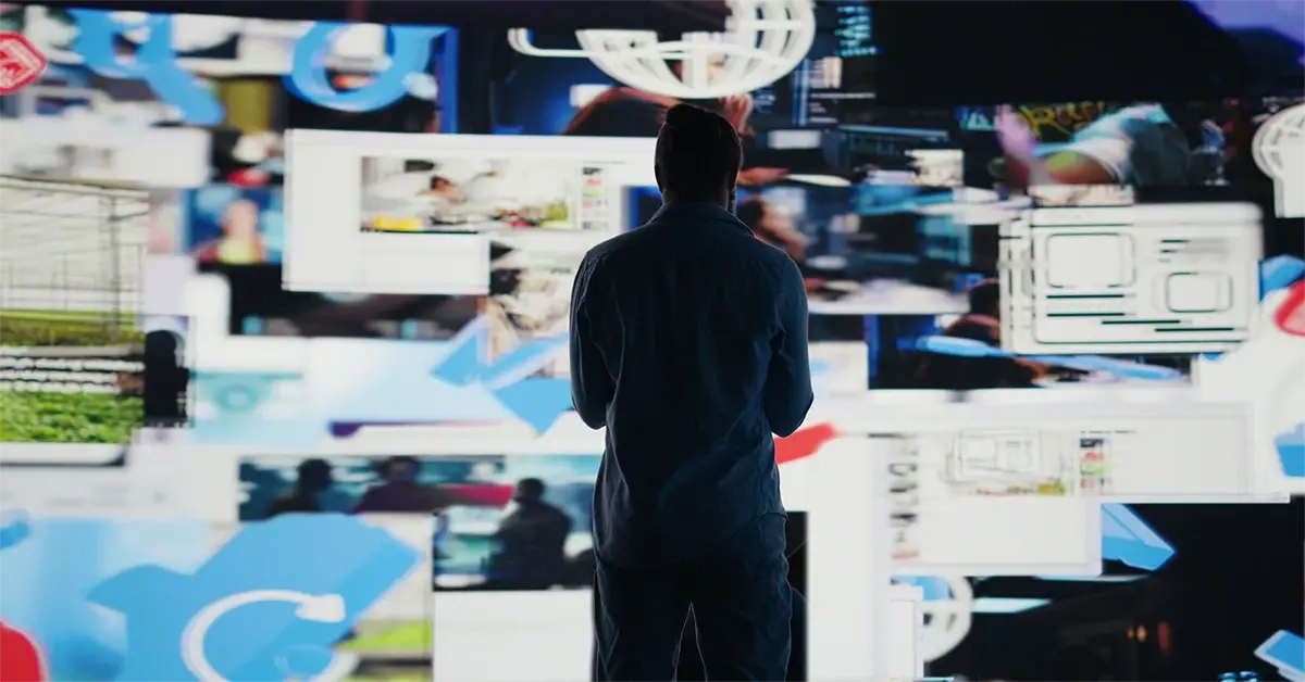 Person facing a wall of overlapping digital screens and social media content, representing information overload and the challenge of analyzing massive volumes of online data