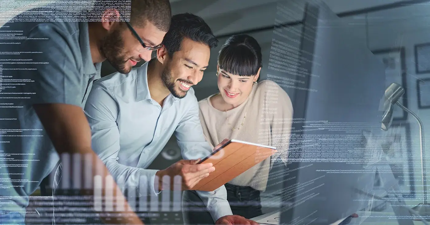 Team reviewing data on a tablet with overlaid code and system visuals, representing human oversight of AI-driven workflows and autonomous systems.