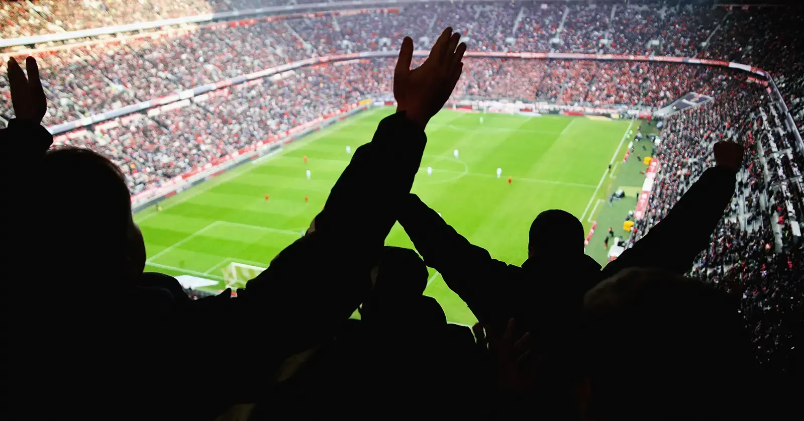 Silhouetted fans in a packed football stadium underscore the crowd density and security challenges of major sporting events.