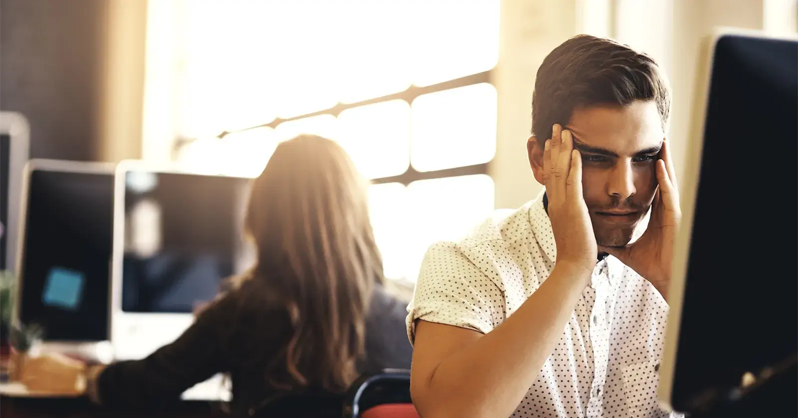 Man in office stressed about falling victim to a fraud attempt