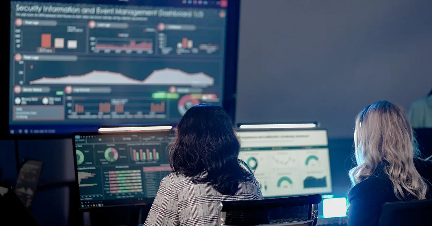 Security analysts monitor real-time dashboards and global threat data, demonstrating situational awareness and proactive risk detection in corporate security environments.