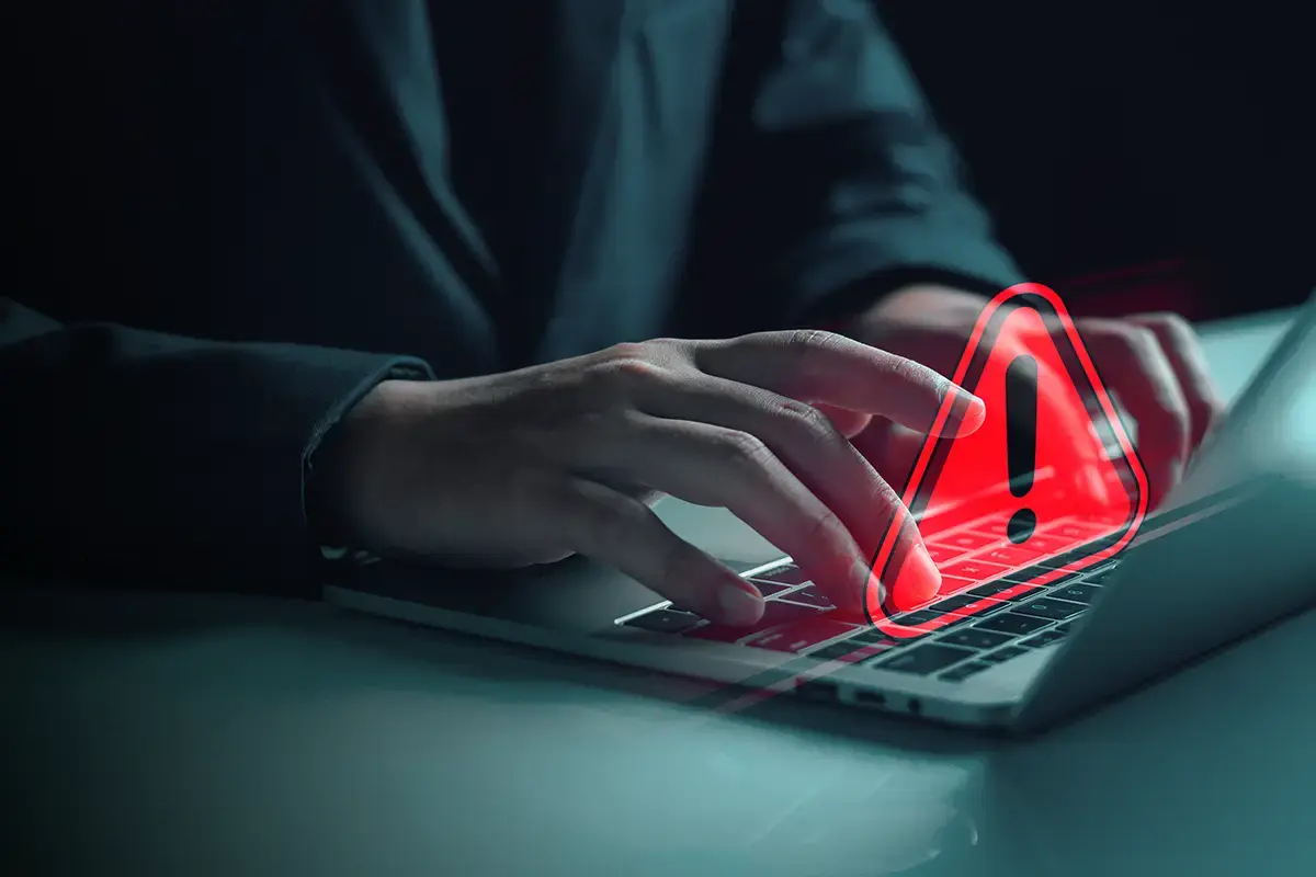 Executive using laptop with an overlayed red alert icon